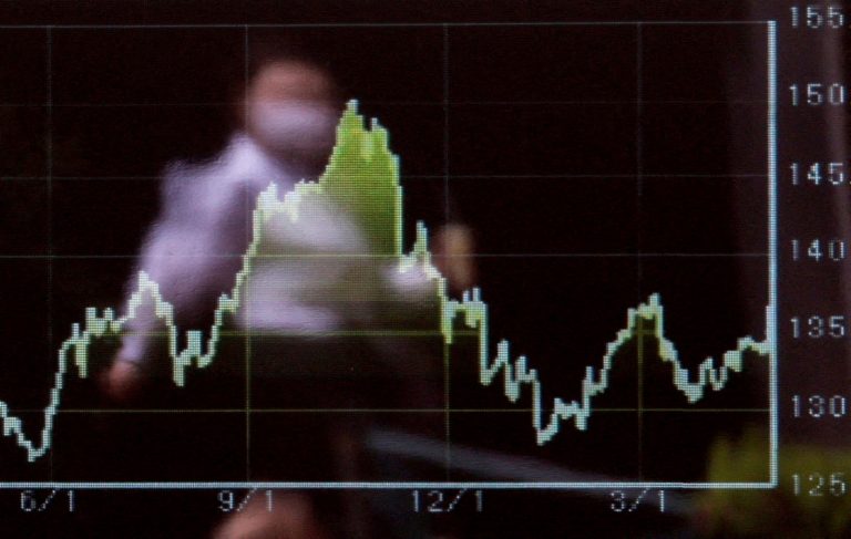 FILE PHOTO: A passerby is reflected on an electric monitor displaying the graph of recent moments of the Japanese yen exchange rate against the U.S